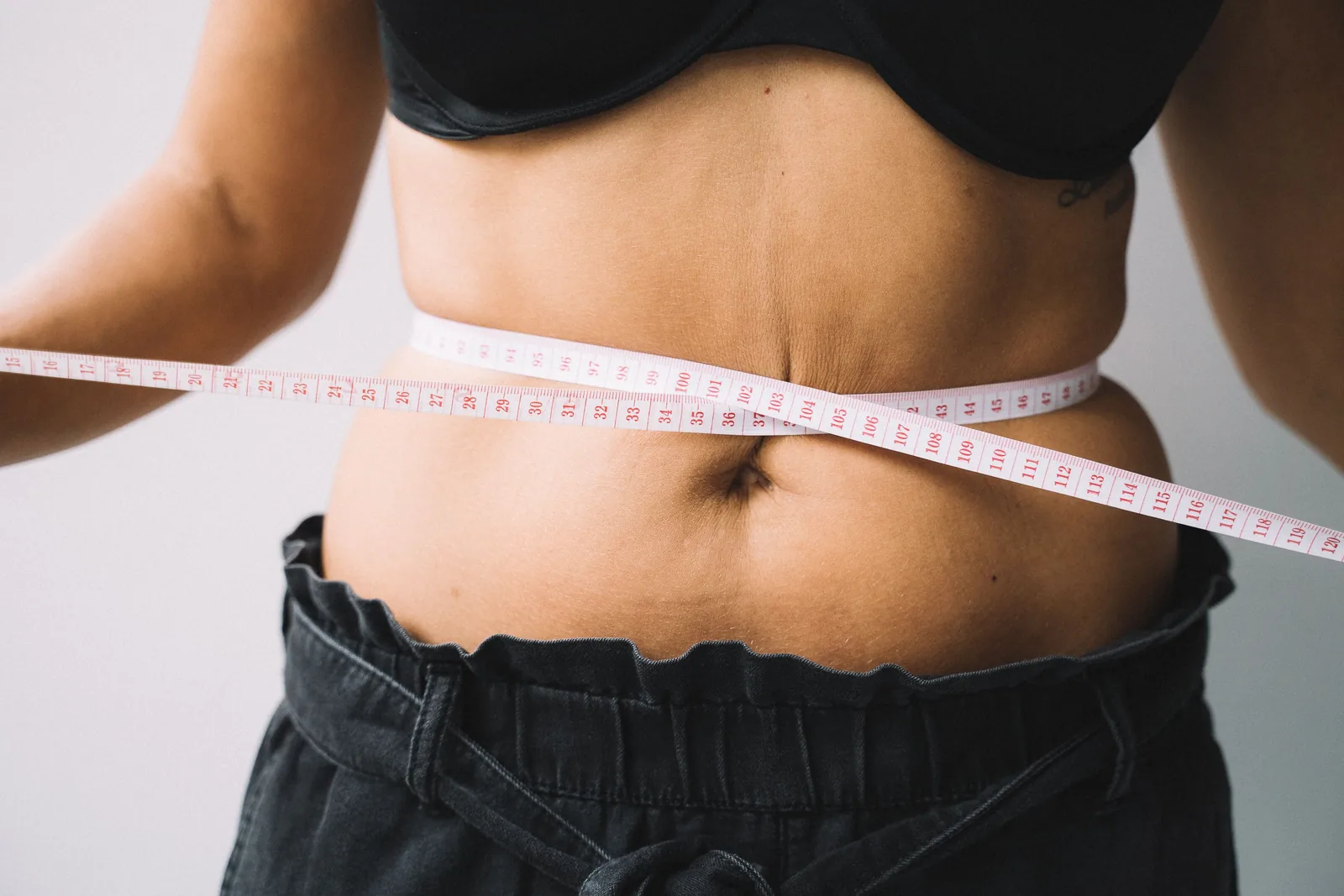 Waist measured with a white tape measure